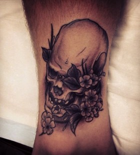 Skull and flowers tattoo by Pari Corbitt