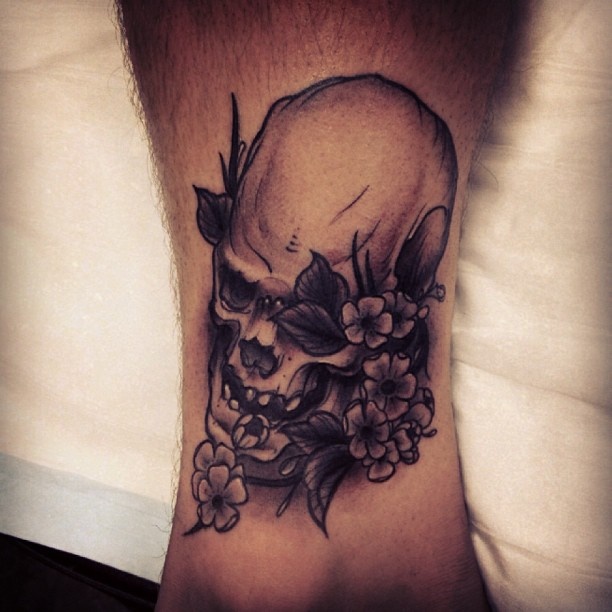 Skull and flowers tattoo by Pari Corbitt