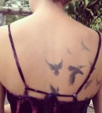 modern tattoo subtle birds on back