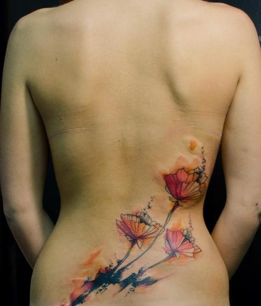 watercolor flowers tattoo on lower back by klaim