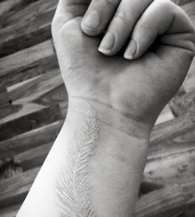 wrist tattoo white ink feather