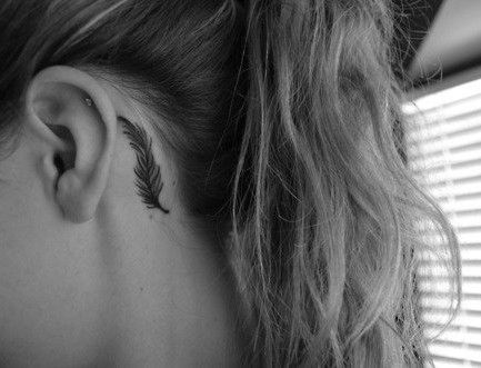 black feather tattoo behind girls ear