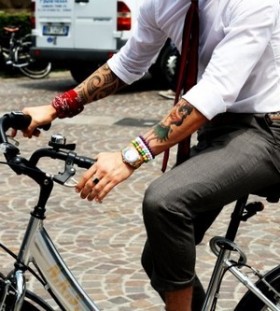 man with tattoos on a bike