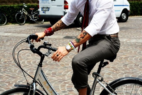 man with tattoos on a bike
