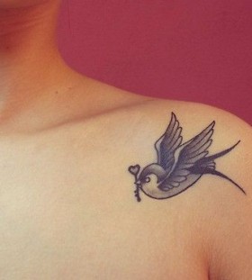 Tattoo of a swallow with a key