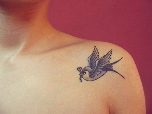 Tattoo of a swallow with a key