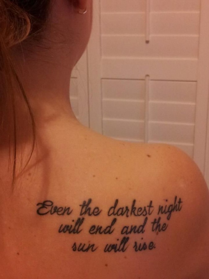 Girl’s back quote tattoo