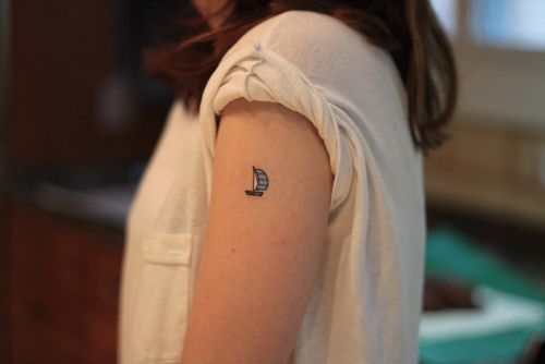 Small blue ship tattoo