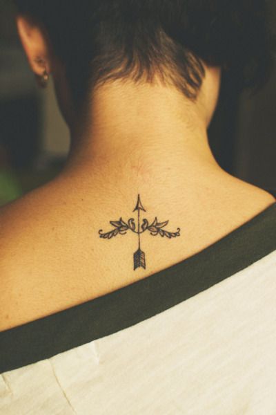 Woman’s back arrow tattoo