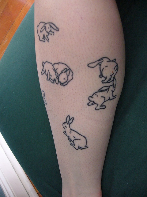 A lot of black rabbits tattoos on arm