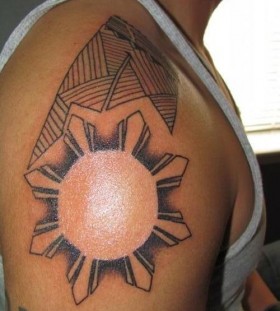 Adorable black sun tattoo on shoulder