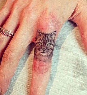 Adorable realistic cat tattoo on finger