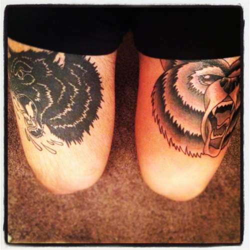 Angry black cat and brown bear tattoo on leg