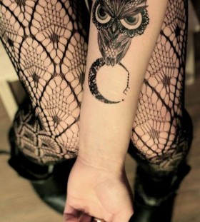 Angry black owl and moon tattoo on arm