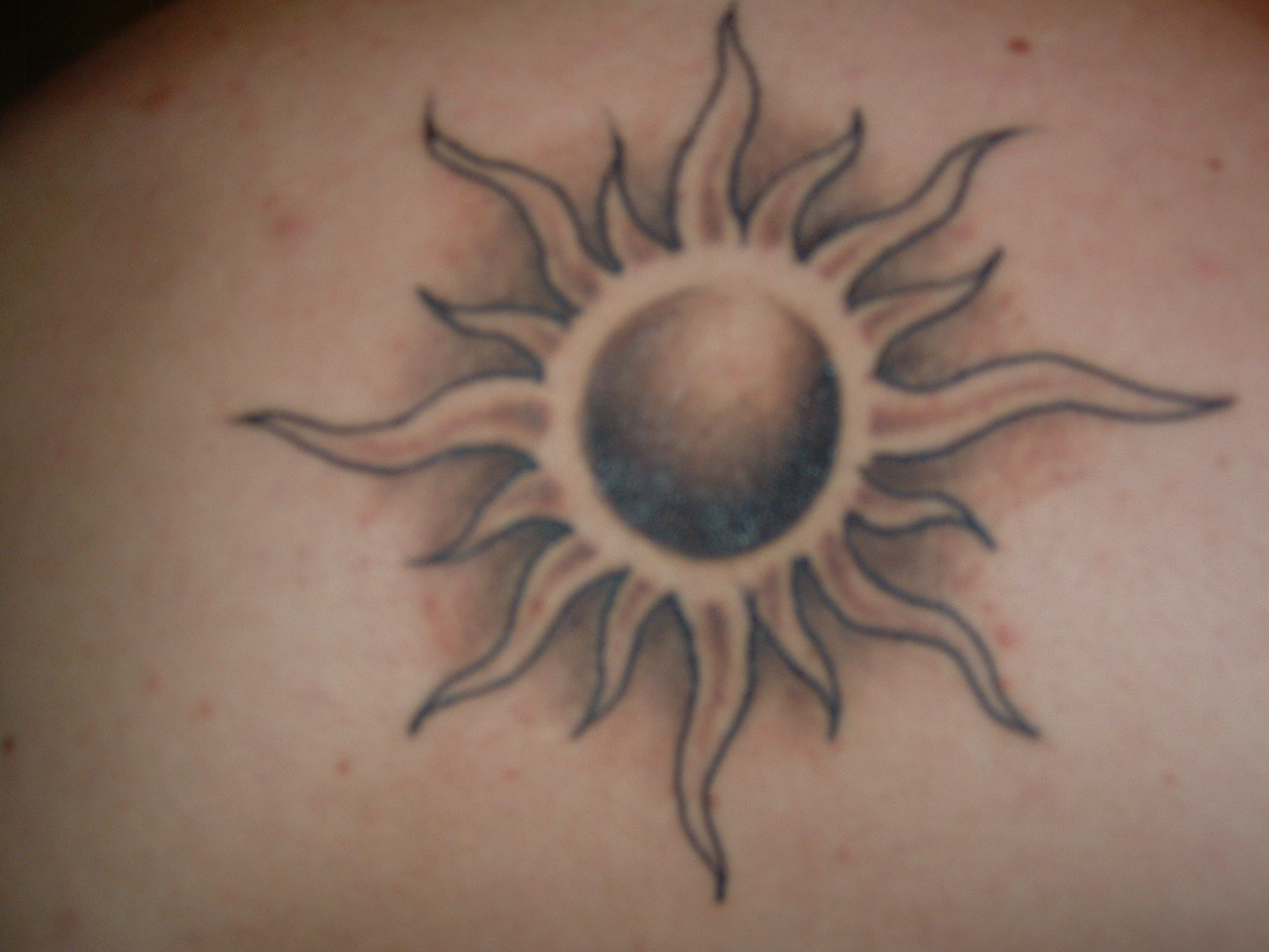 Artistic-black-sun-tattoo-on-arm.jpg