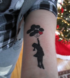 Bansky girl tattoo on arm