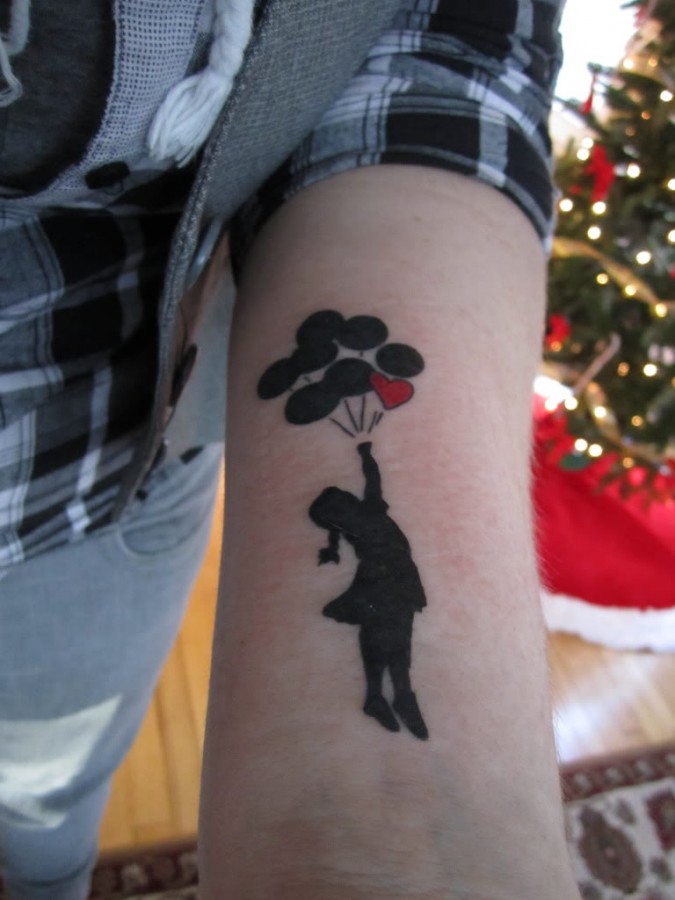 Bansky girl tattoo on arm
