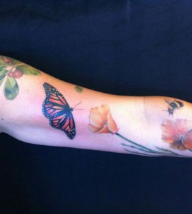 Beautiful butterfly, flowers and poppy tattoo on arm