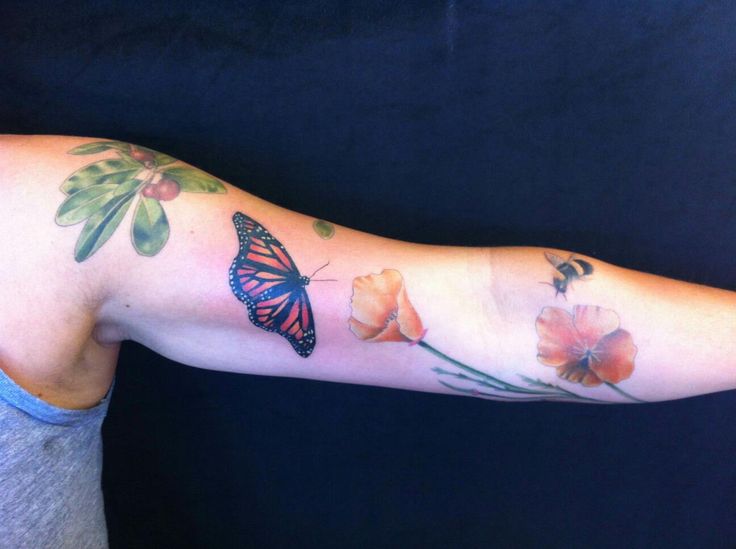 Beautiful butterfly, flowers and poppy tattoo on arm