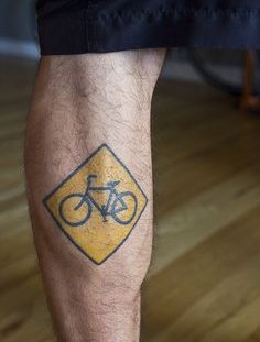 Bicycle sign tattoo on leg