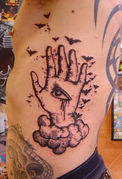Birds, hand and eye tattoo on arm