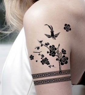 Birds, trees, flowers and black lace tattoo on arm