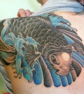 Black and blue fish tattoo on arm