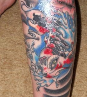 Black and blue fish tattoo on leg