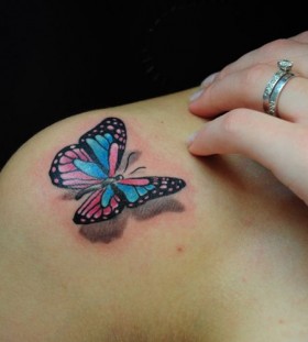Black and red butterfly tattoo on shoulder