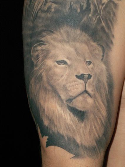 Black and white lion tattoo on leg
