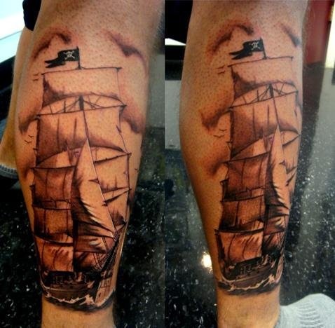 Black and white pirate ship tattoo on leg