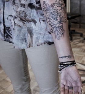 Black and white poppy tattoo on arm