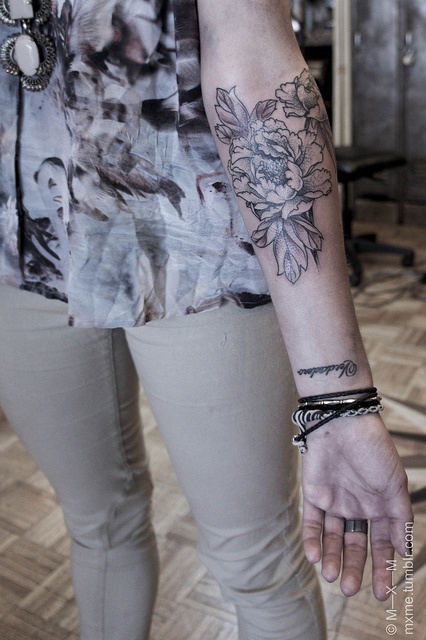 Black and white poppy tattoo on arm