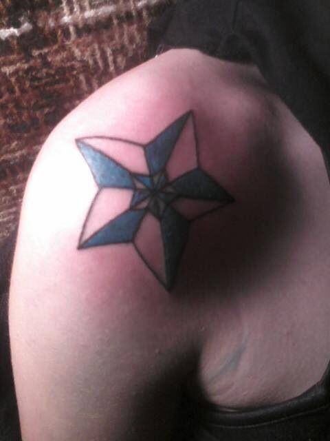 Black and white star tattoo on shoulder
