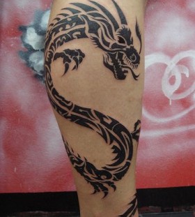 Black angry dragon tribal tattoo on leg