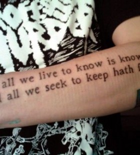 Black arm quote tattoo on arm
