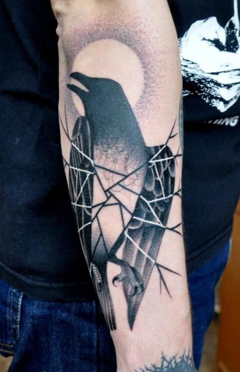 Black bird and moon tattoo on arm