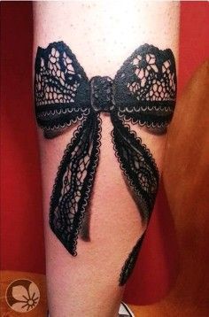 Black bow lace tattoo on leg