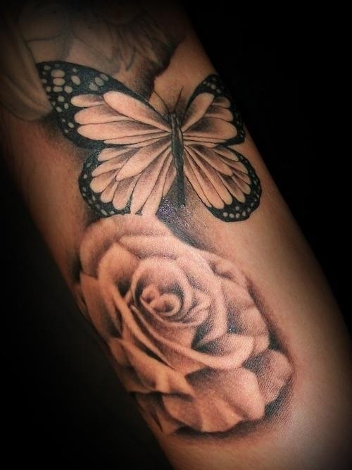 Black butterfly and rose tattoo on arm