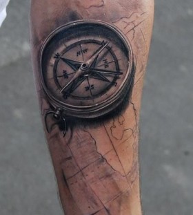Black compass and map tattoo on arm