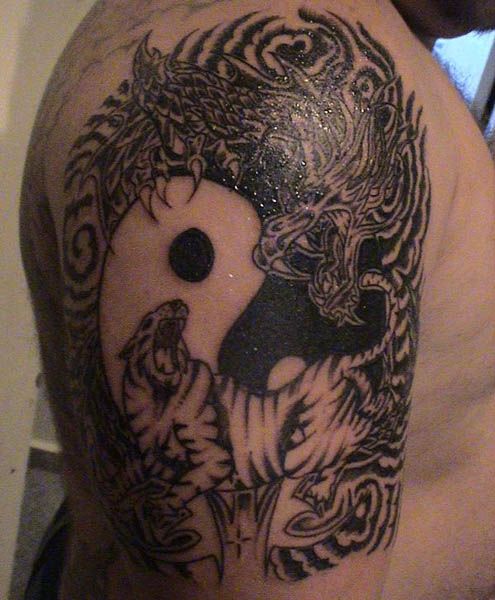 Black dragon and tiger tattoo on arm