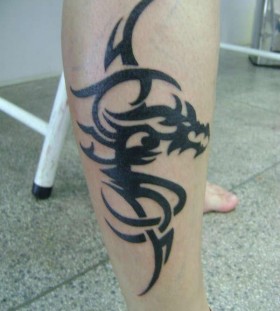 Black dragon tribal tattoo on leg