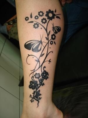 Black flowers and butterfly tattoo on leg