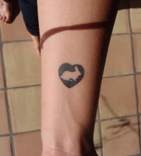 Black heart and rabbit tattoo on arm