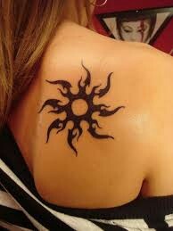 Black ink sun tattoo on shoulder