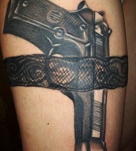 Black lace and gun tattoo