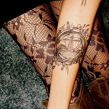 Black lace and ship tattoo on arm