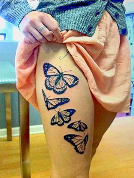 Black leg butterfly tattoo on arm