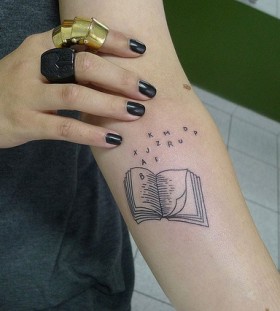 Black letters and book tattoo on arm