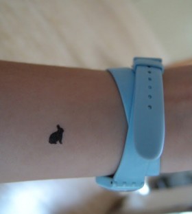 Black, lovely, small rabbit tattoo on arm
